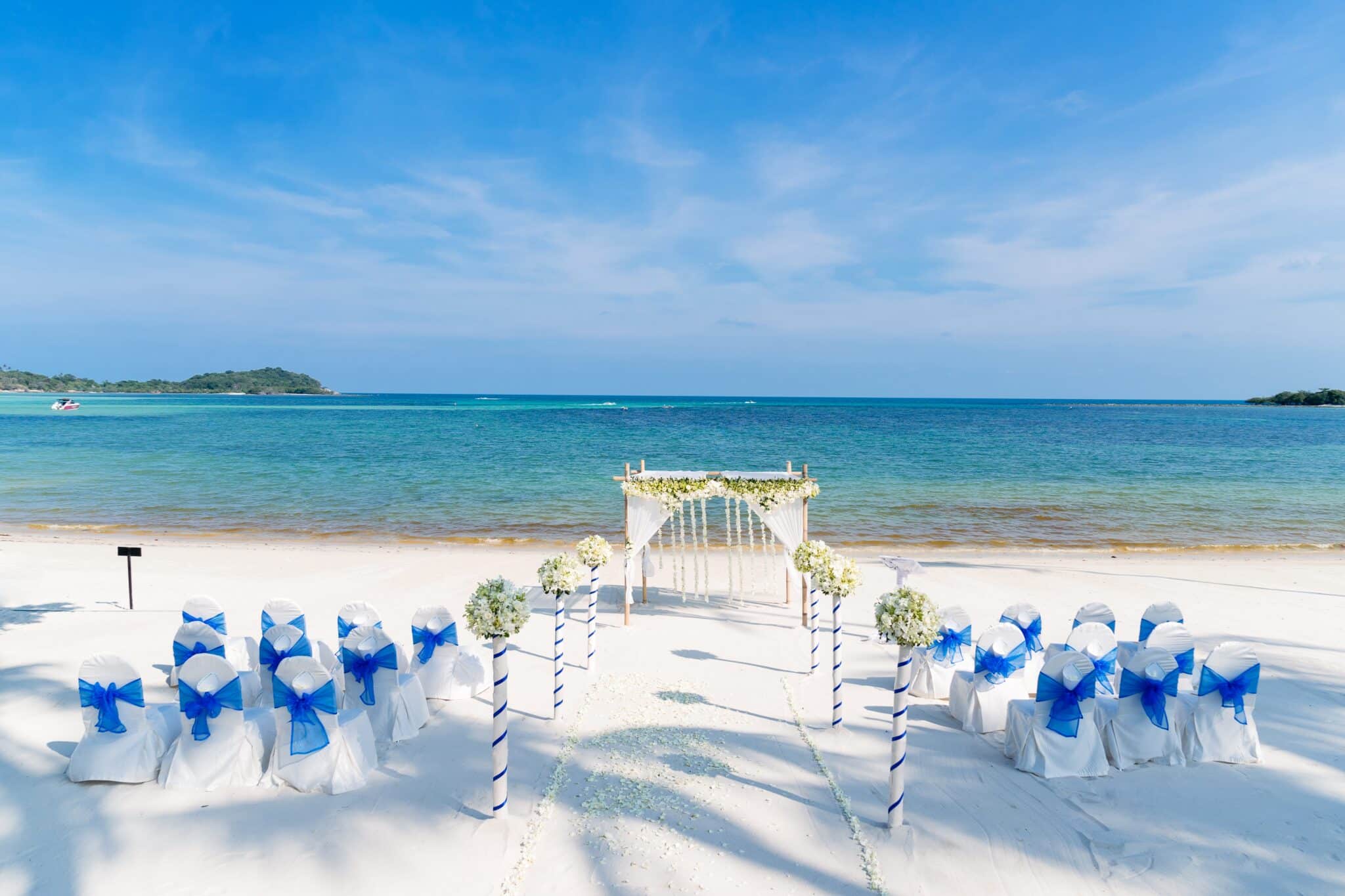 Beautiful beach wedding venue setting with flowers decoration, panoramic ocean view