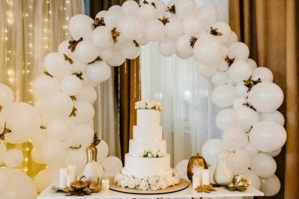 Delicious wedding reception. Cake on a background balloons. Decorated table for wedding. White ball