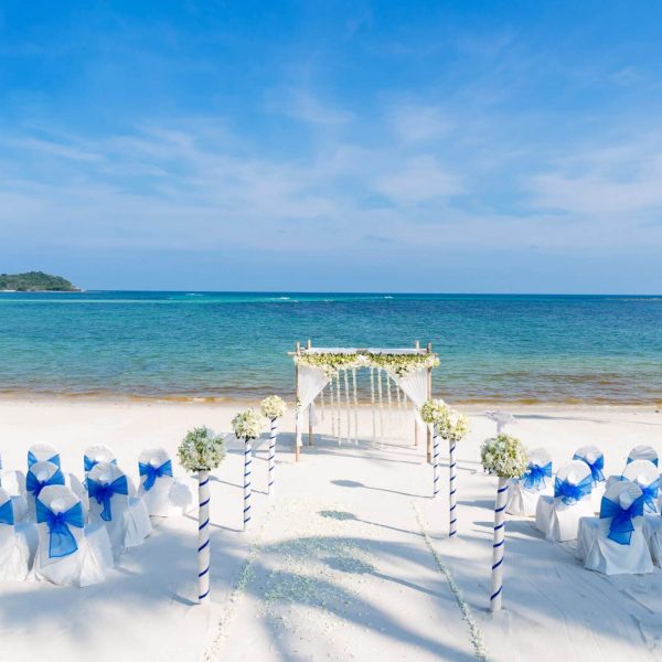Beautiful beach wedding venue setting with flowers decoration, panoramic ocean view